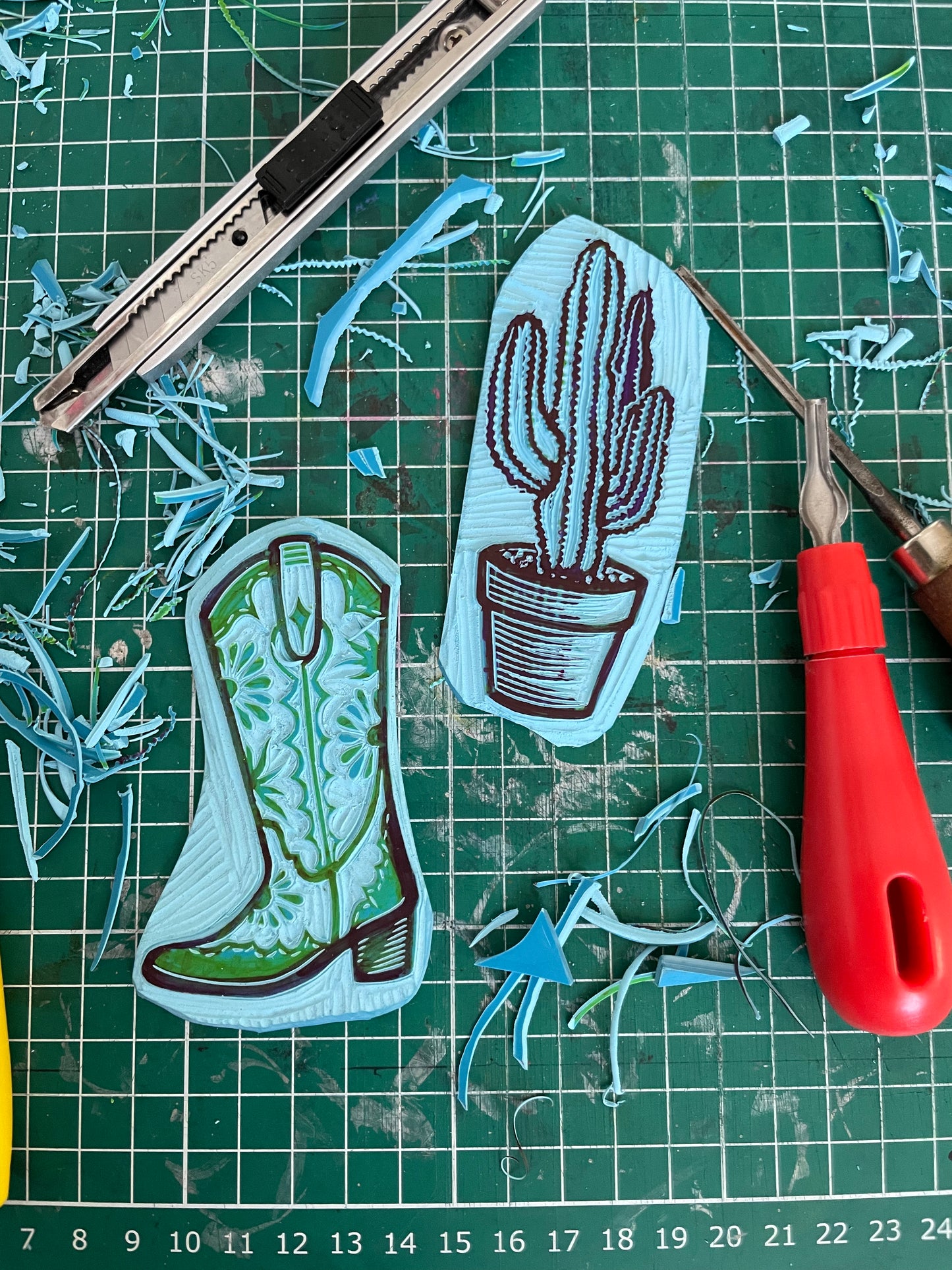 a linocut art print of a carved cowboy boot and cactus plant