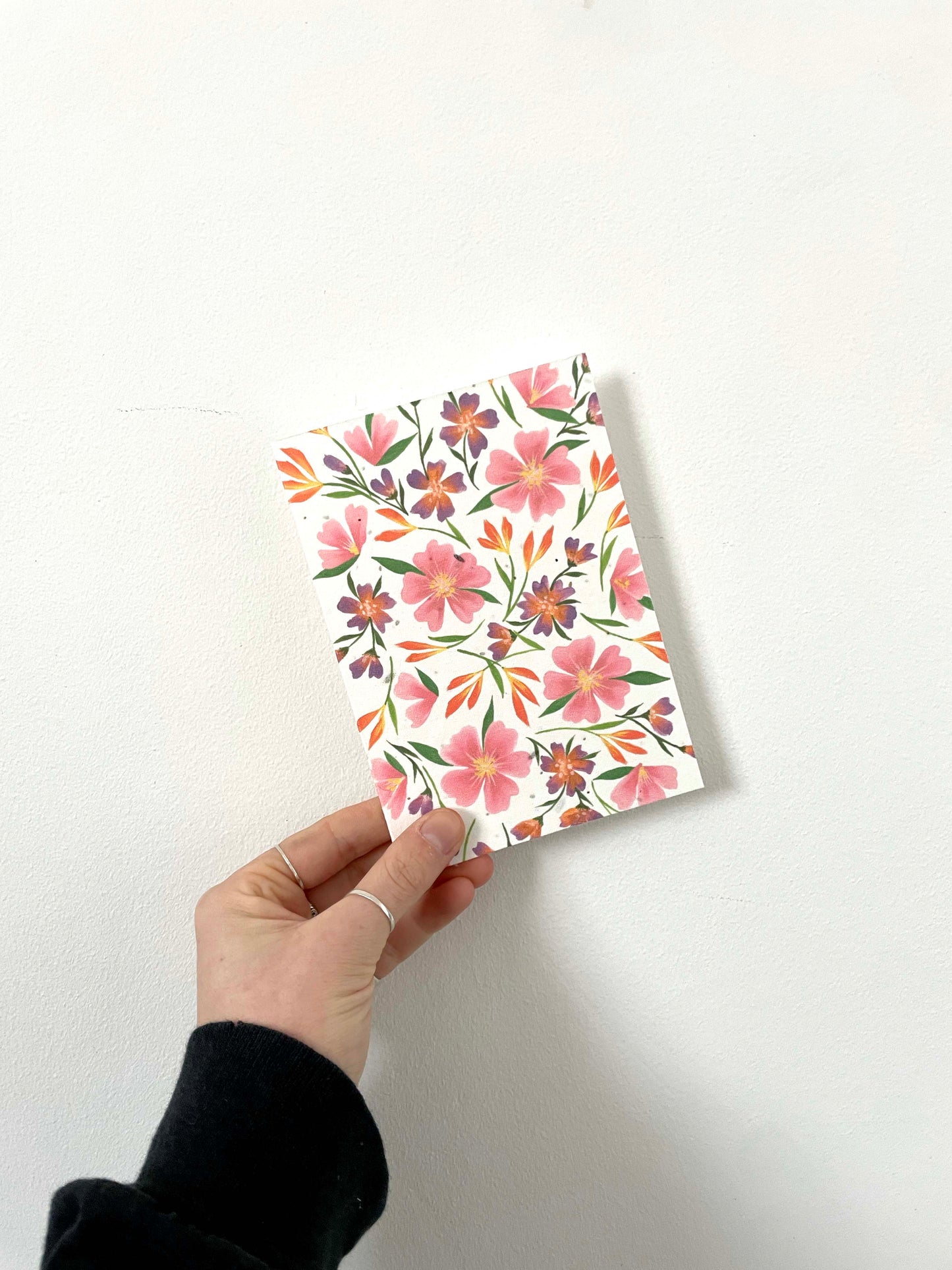 A pink floral pattern wildflower seed greetings card on recycled paper with flowers and leaves